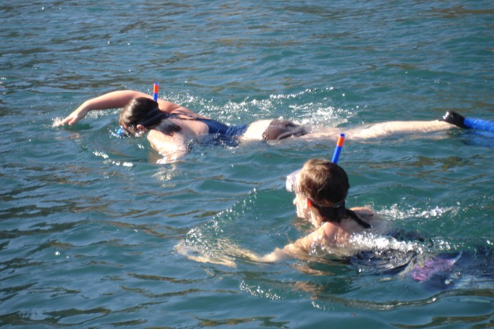 a girl riding a wave on a surfboard in the water