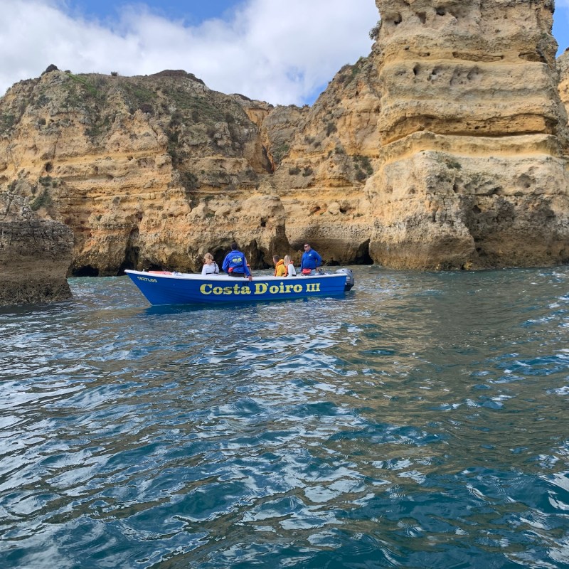 a small boat in a body of water with a mountain in the background