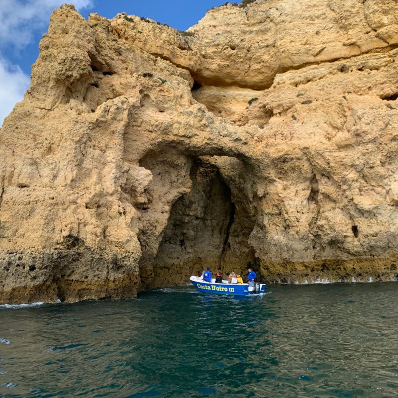 a person sitting on a rock next to a body of water