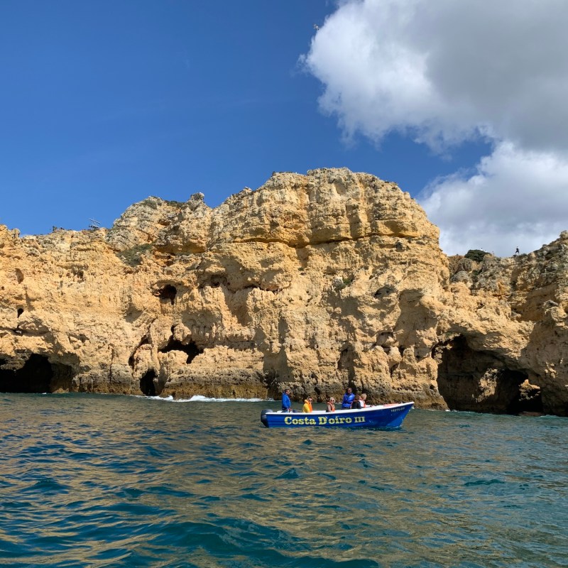 a small boat in a body of water with a mountain in the background